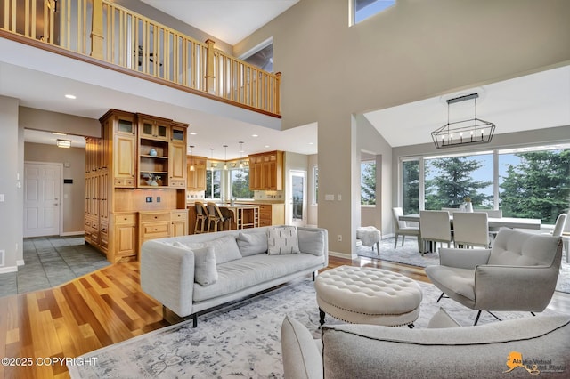 16268 Noble Point Dr, Anchorage, AK 99516 - living room with a chandelier, light wood-style floors, a towering ceiling, and recessed lighting