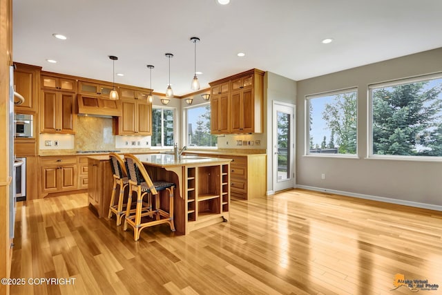 16268 Noble Point Dr, Anchorage, AK 99516 - kitchen with light wood-type flooring, custom range hood, open shelves, an island with sink, and recessed lighting