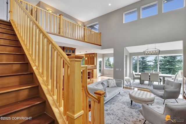 16268 Noble Point Dr, Anchorage, AK 99516 - living area with stairs, a chandelier, a towering ceiling, recessed lighting, and wood finished floors