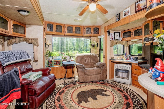 living room featuring ceiling fan and heating unit