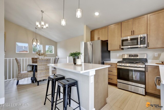 kitchen with lofted ceiling, stainless steel appliances, light hardwood / wood-style floors, and a notable chandelier