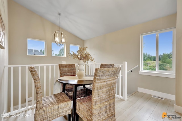 dining space with lofted ceiling, a wealth of natural light, light wood-type flooring, and an inviting chandelier