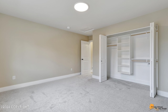 unfurnished bedroom with light carpet and a closet