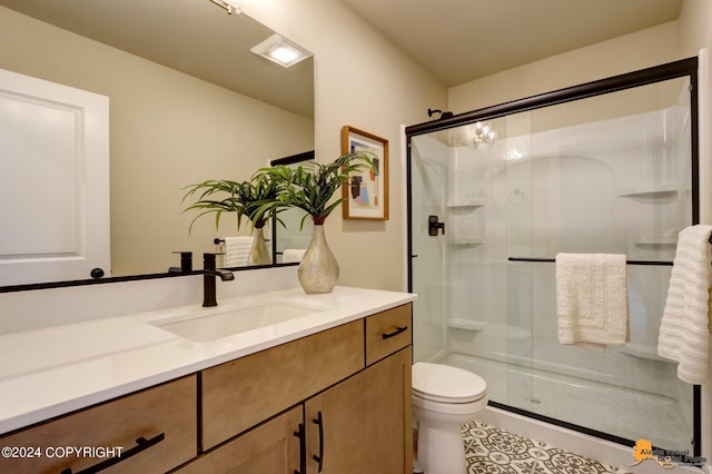 bathroom featuring tile patterned floors, toilet, a shower with door, and vanity