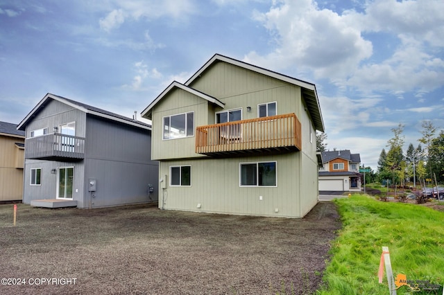 back of property featuring a balcony and a garage