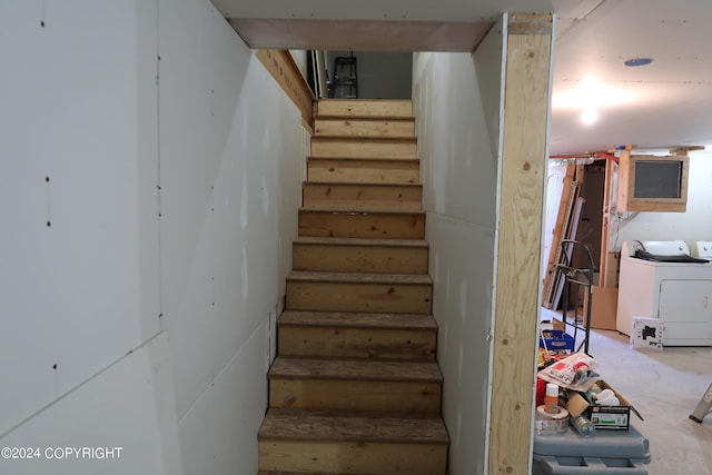 staircase with concrete flooring and washer / dryer