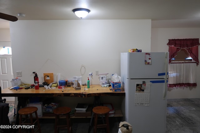 kitchen featuring a kitchen bar and white fridge