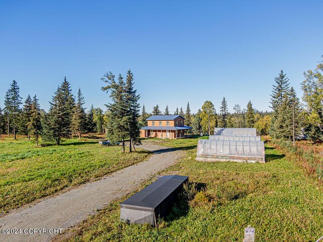 view of home's community with a yard, a rural view, and an outdoor structure