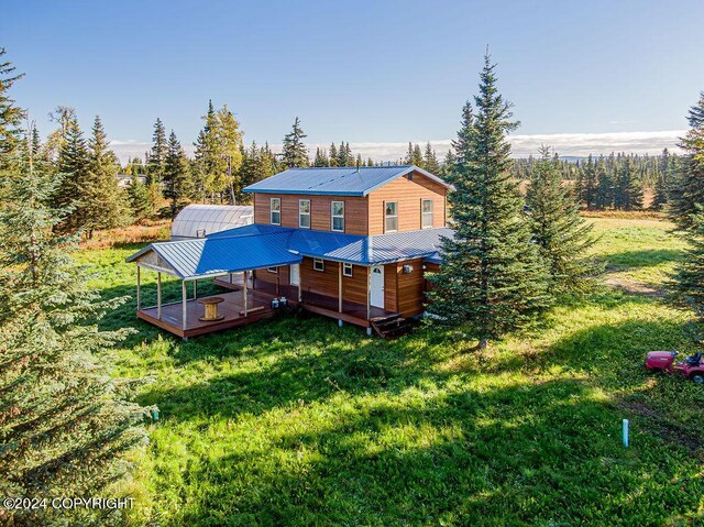 rear view of property featuring a lawn and a wooden deck