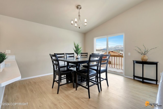 dining area featuring vaulted ceiling, a chandelier, and light hardwood / wood-style floors