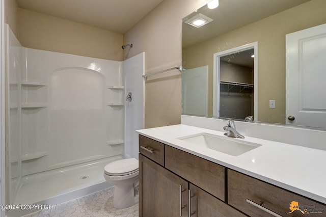 bathroom with a shower, tile patterned floors, toilet, and vanity