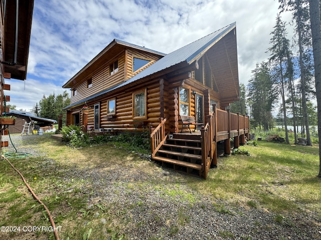 34335 Keystone Dr, Soldotna, AK 99669 - view of side of home featuring a deck, a metal roof, log exterior, and a lawn