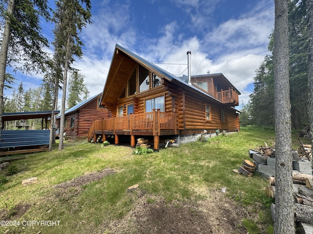 34335 Keystone Dr, Soldotna, AK 99669 - rear view of house featuring log exterior, a lawn, and a deck