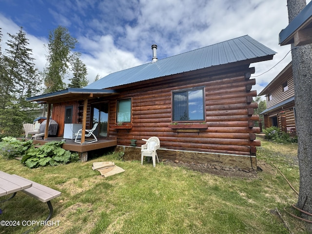 34335 Keystone Dr, Soldotna, AK 99669 - rear view of house featuring log siding, a metal roof, a lawn, and a wooden deck