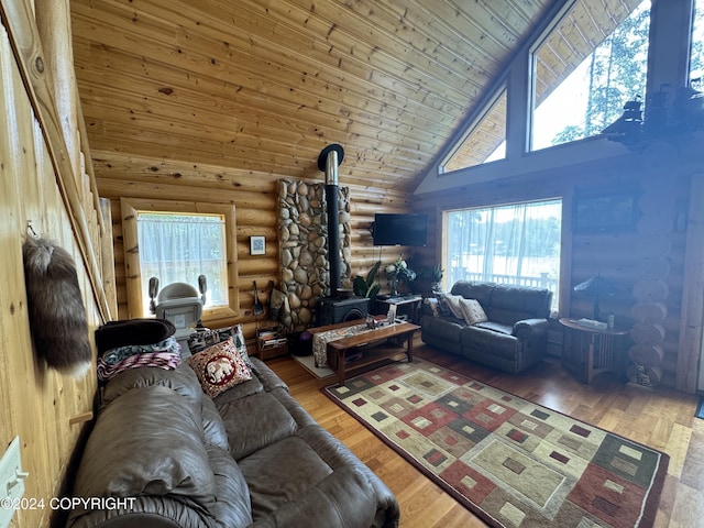 34335 Keystone Dr, Soldotna, AK 99669 - living area with rustic walls, high vaulted ceiling, a wood stove, wooden ceiling, and wood finished floors