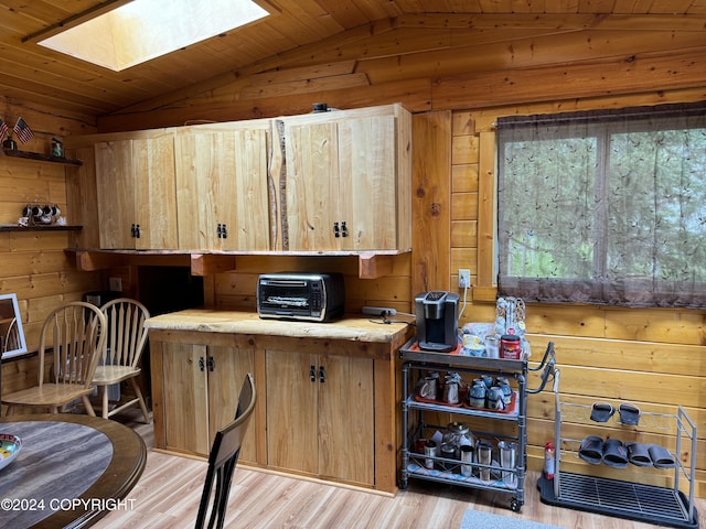 34335 Keystone Dr, Soldotna, AK 99669 - kitchen featuring vaulted ceiling, a skylight, wood walls, light wood-style floors, and light countertops