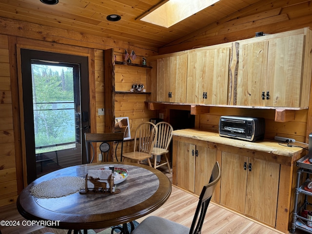 34335 Keystone Dr, Soldotna, AK 99669 - dining room featuring a skylight, lofted ceiling, light wood finished floors, wooden walls, and wooden ceiling