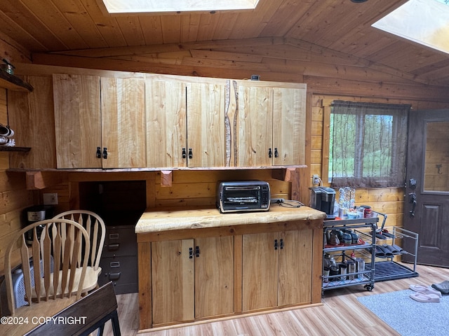 34335 Keystone Dr, Soldotna, AK 99669 - office area featuring lofted ceiling, a skylight, wooden walls, and light wood-style flooring