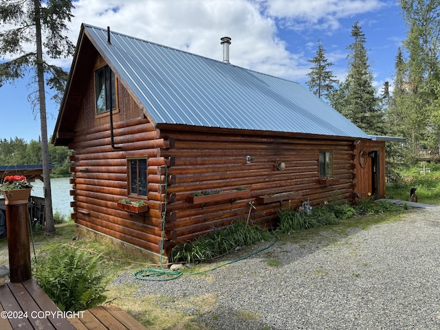 34335 Keystone Dr, Soldotna, AK 99669 - view of side of property featuring log exterior, an outdoor structure, and a metal roof