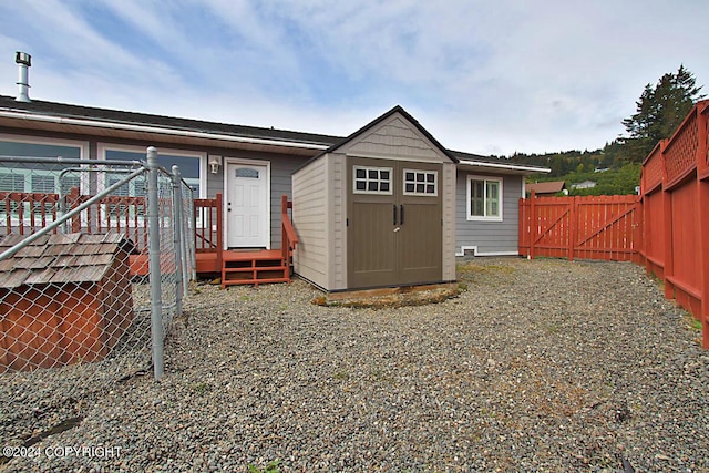 back of property featuring an outbuilding, a storage unit, and a fenced backyard