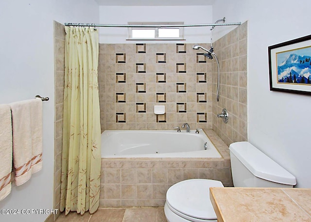 bathroom featuring vanity, tile patterned floors, toilet, and tiled shower / bath