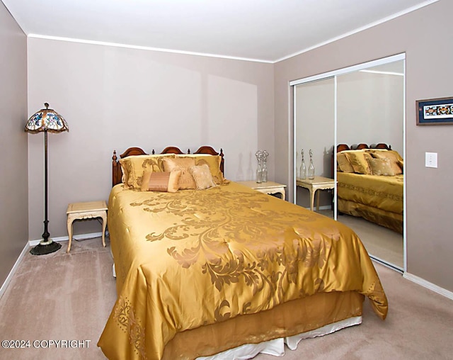 carpeted bedroom featuring a closet, baseboards, and ornamental molding