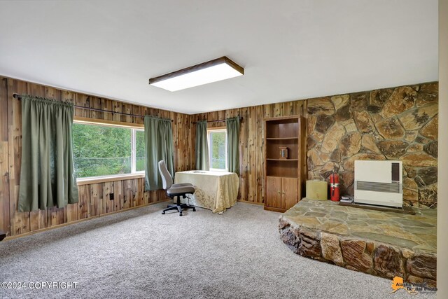 office featuring carpet flooring, heating unit, and wood walls