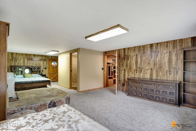 carpeted bedroom featuring wood walls