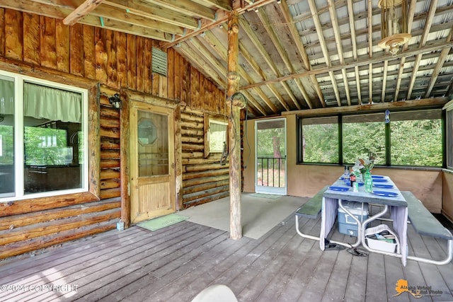 unfurnished sunroom featuring vaulted ceiling