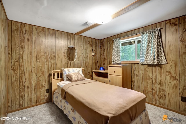 carpeted bedroom featuring wood walls