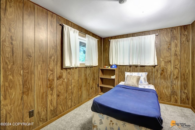 carpeted bedroom with wood walls