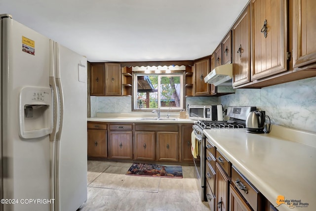 kitchen featuring light tile patterned floors, stainless steel appliances, backsplash, and sink