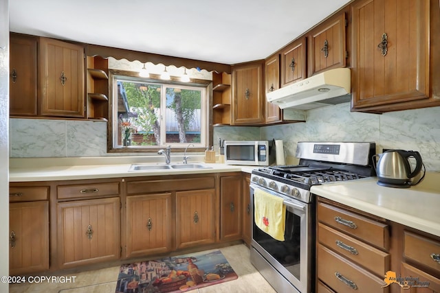 kitchen featuring appliances with stainless steel finishes, tasteful backsplash, light tile patterned floors, and sink