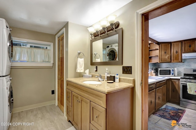 bathroom with sink, tasteful backsplash, stacked washer and dryer, and hardwood / wood-style floors