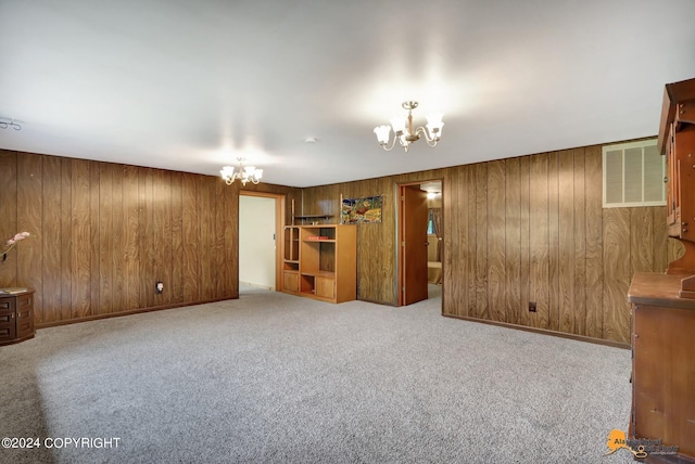 interior space featuring light carpet, wooden walls, and a chandelier