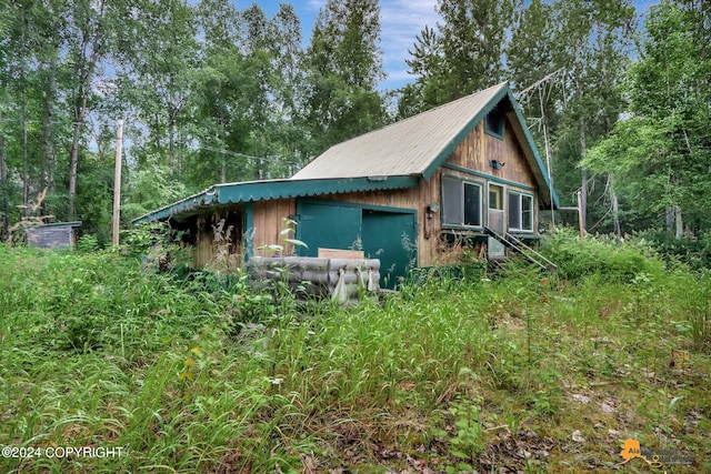 view of property exterior with a garage and an outbuilding