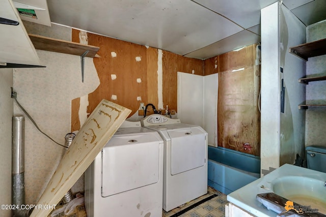 laundry area with sink, tile patterned floors, independent washer and dryer, and wooden walls