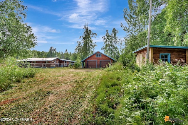 view of yard featuring a garage and an outdoor structure