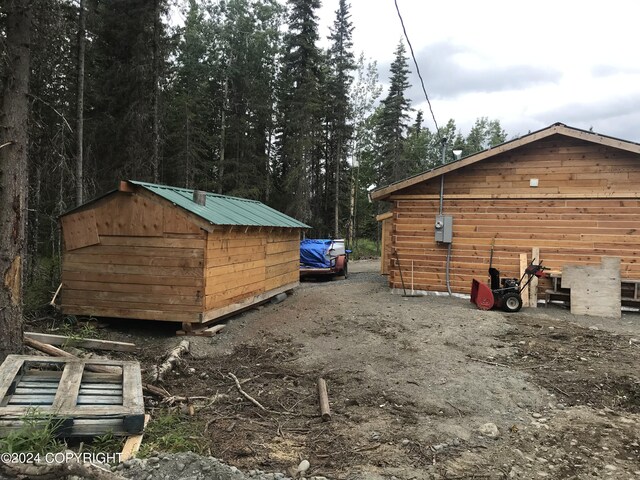 view of property exterior with a storage unit