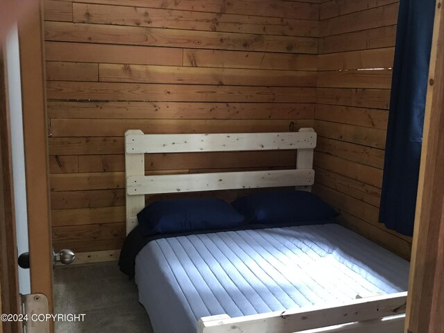 unfurnished bedroom featuring wooden walls and carpet flooring