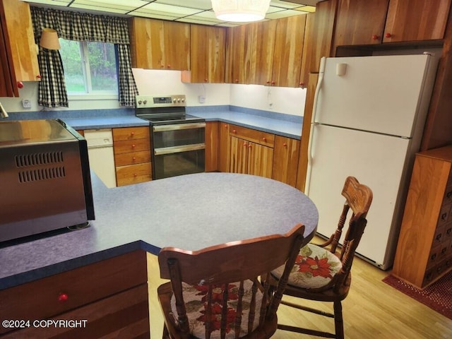 kitchen featuring white fridge, light wood-type flooring, and stainless steel electric range