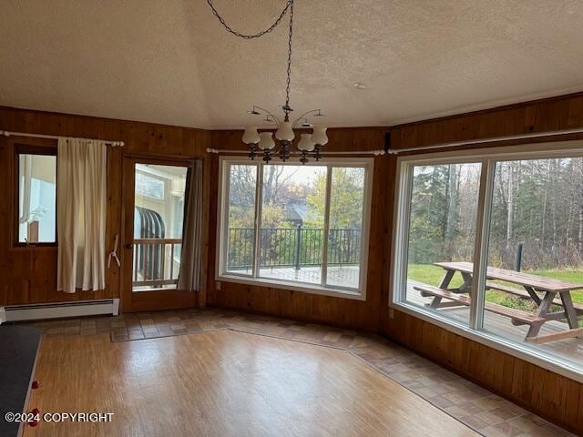 unfurnished sunroom with vaulted ceiling, an inviting chandelier, and a baseboard radiator