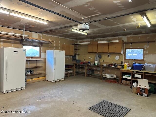 garage featuring white refrigerator and a garage door opener