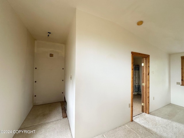 hall featuring light carpet and vaulted ceiling