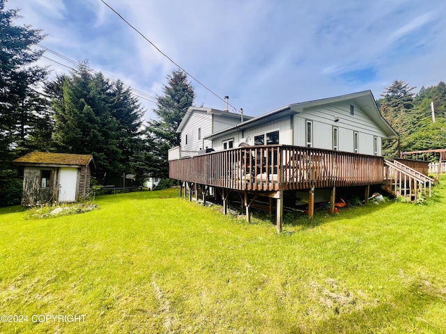 rear view of property with a yard, a deck, and a storage shed