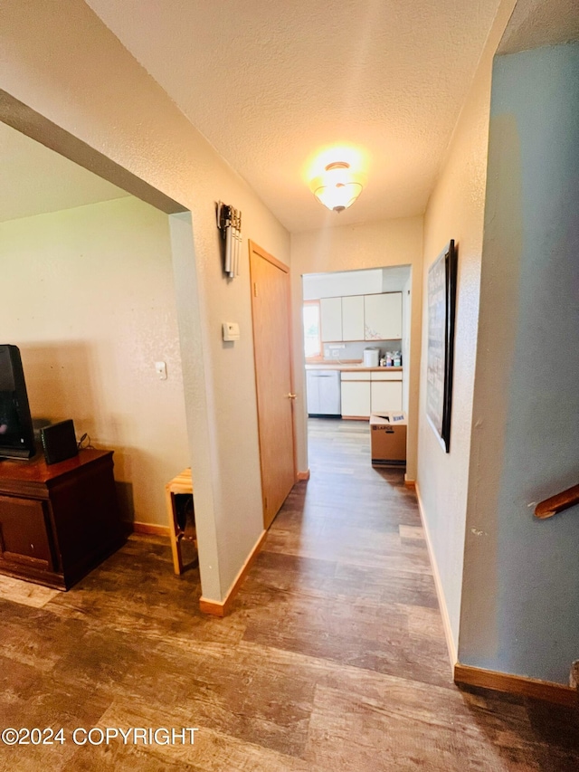 corridor featuring hardwood / wood-style floors and a textured ceiling