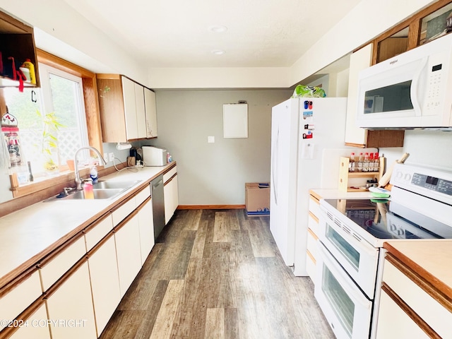 kitchen with white appliances, sink, light hardwood / wood-style flooring, and white cabinets