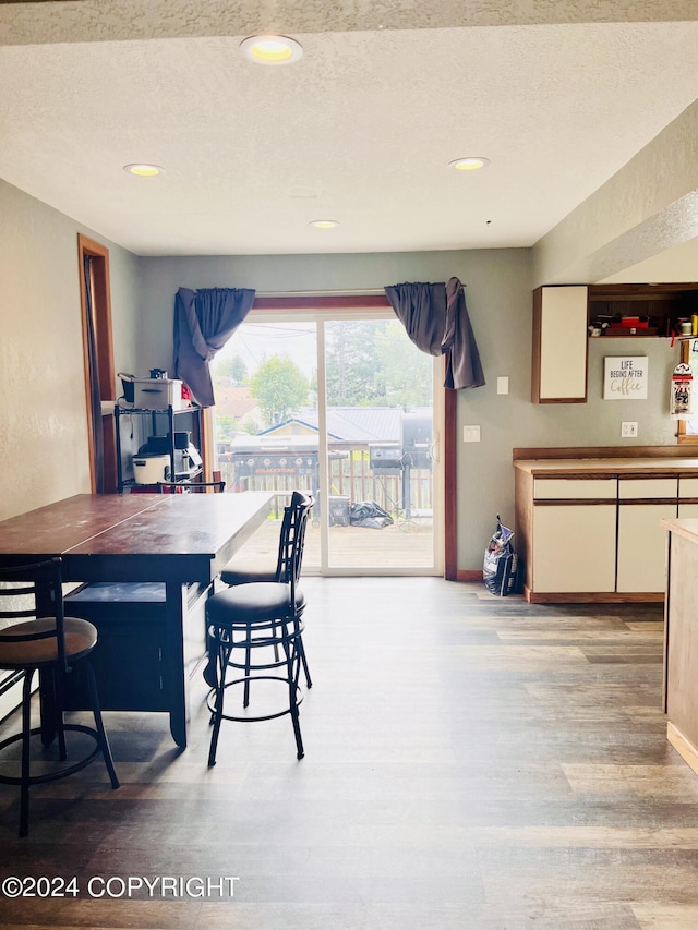 dining room featuring a textured ceiling and light hardwood / wood-style floors