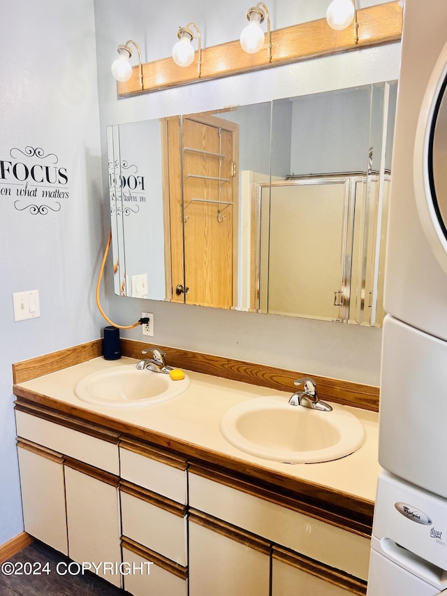 bathroom featuring vanity and stacked washing maching and dryer