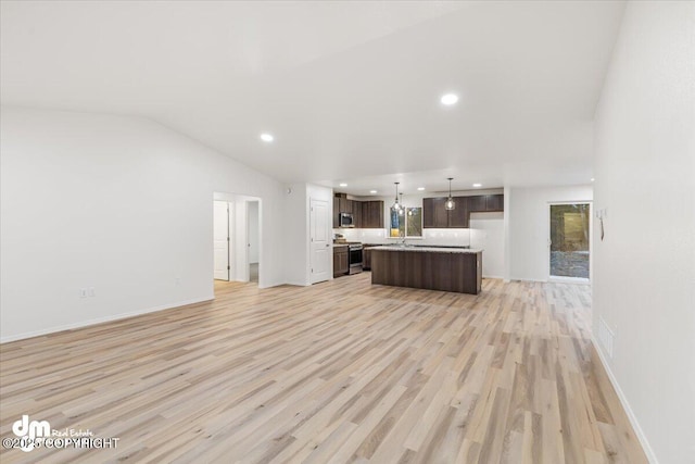 unfurnished living room featuring lofted ceiling and light wood-type flooring